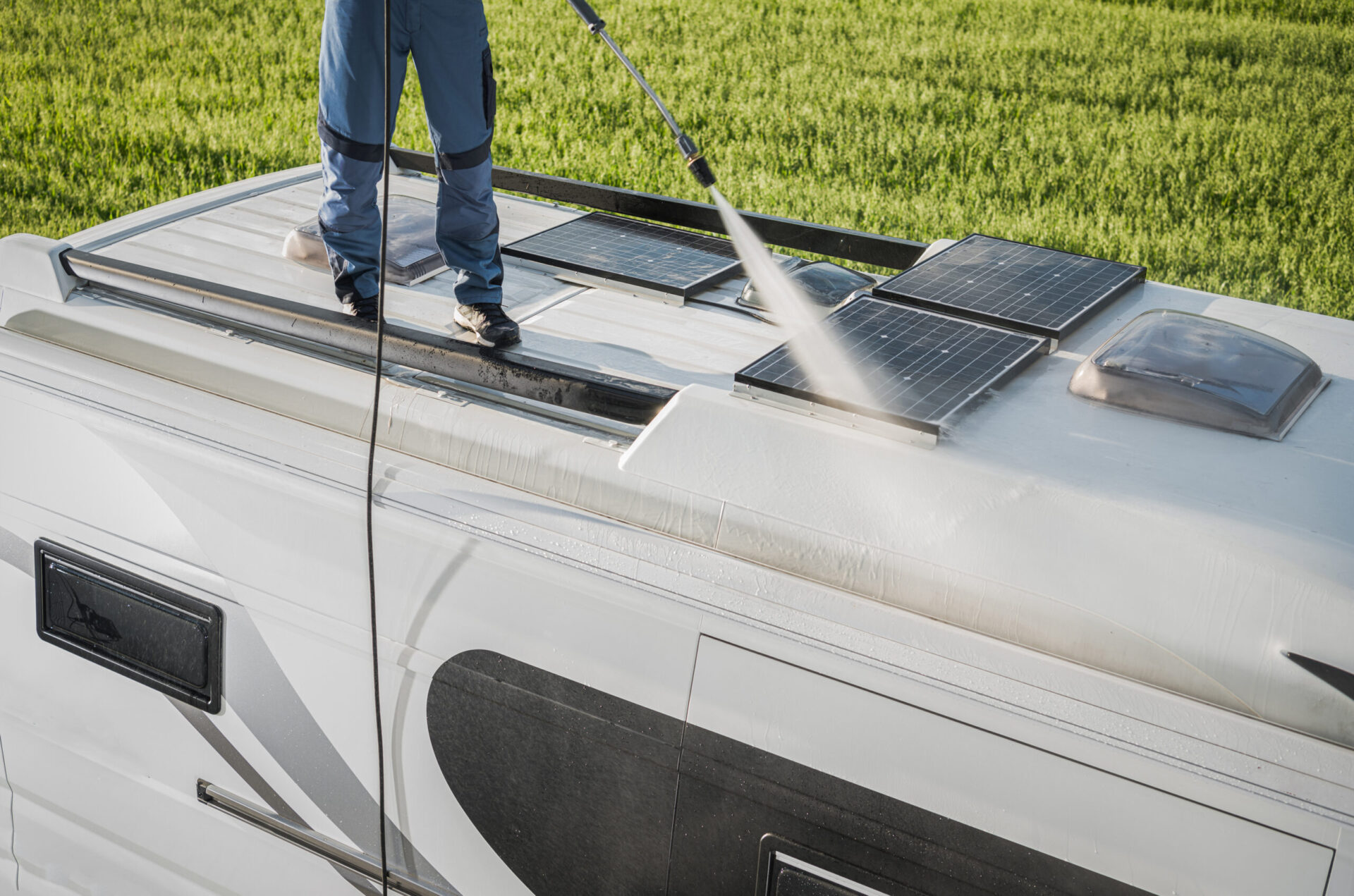 rv industry worker cleaning camper van roof and motorhome solar panels